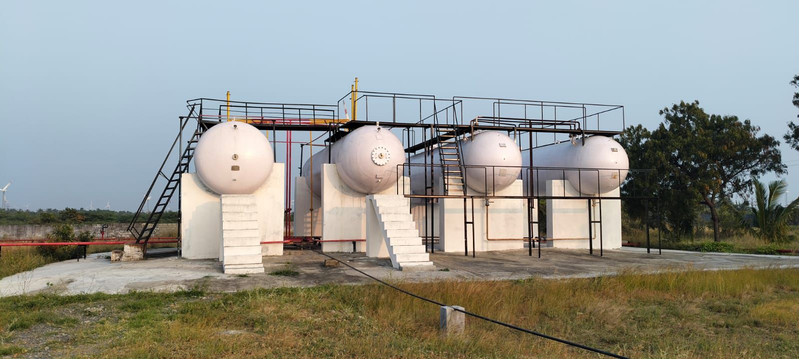 White bulk LPG storage tanks with steel stairs and walkways